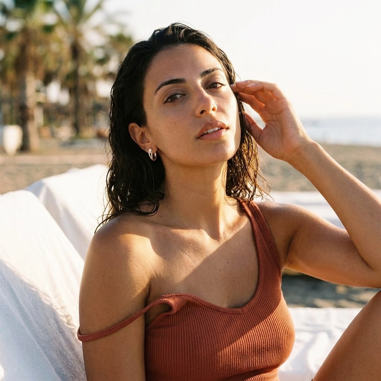 Pear Crystal Huggie Hoops in Gold, worn at a beach club at sunset | SKU: 41007-gold