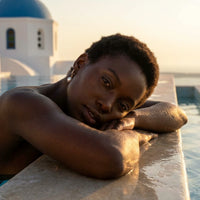 Thumbnail for Pearl Drop Huggie Hoops in Gold, worn by a pool in Santorini | SKU: 41003-gold