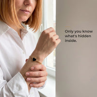 Thumbnail for Woman wearing the gold bracelet with its black heart charm, only she knows the photo inside | SKU: TPH-HRTB-GOLD