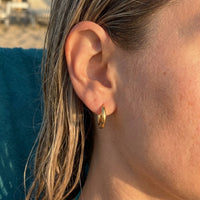Thumbnail for Tiny Huggie Hoops in Gold, close-up on the earlobe | SKU: 41002-gold