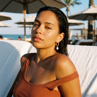 Thumbnail for Twisted Pearl Drop Hoops in Gold, worn at a beach club at sunset | SKU: 41004-gold