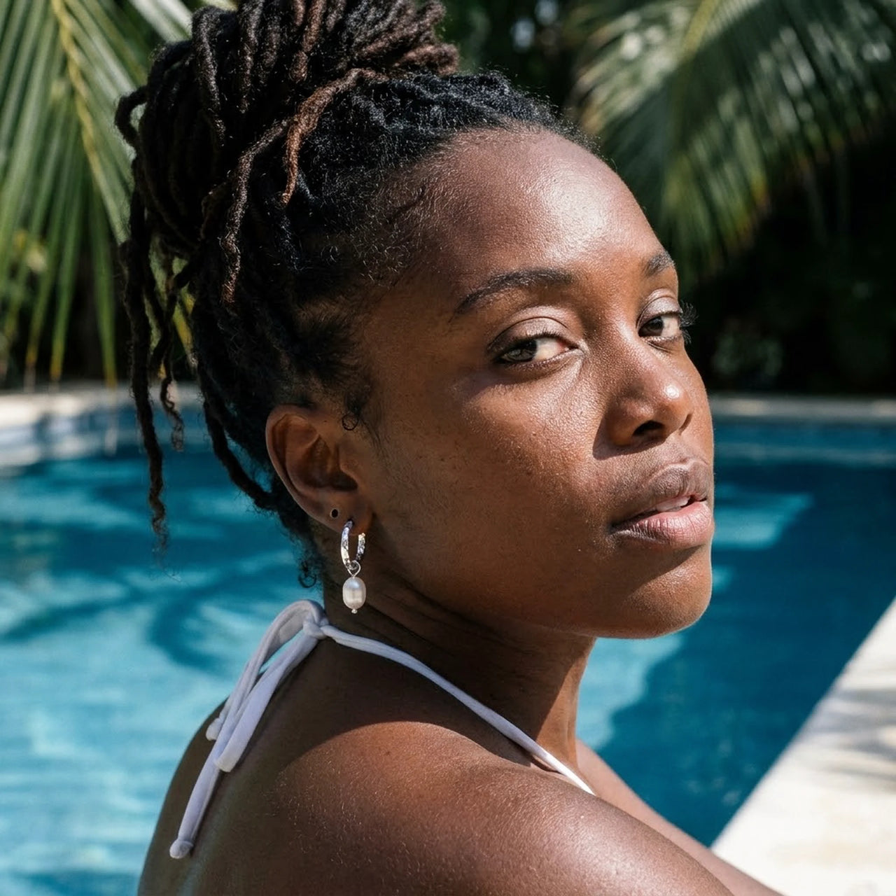 Twisted Pearl Drop Hoops in Silver, worn by a tropical pool | SKU: 41004-silver